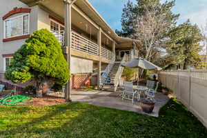 Rear view of house with a fenced backyard, outdoor dining space, stucco siding, and a patio area