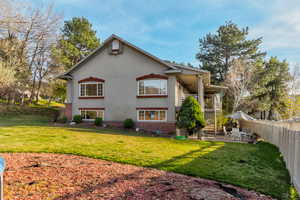 Rear view of property with a patio area, a fenced backyard, brick siding, stucco siding, and a balcony