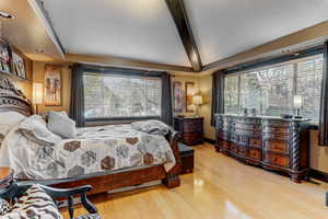 Bedroom featuring light wood-style flooring, a textured ceiling, beam ceiling, and recessed lighting