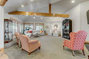 Living room with recessed lighting, light colored carpet, and lofted ceiling