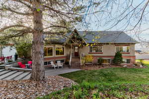 View of front of home featuring brick siding, a patio, and a front yard