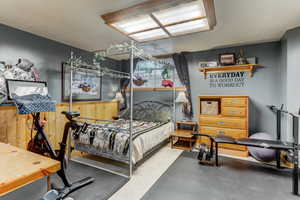 Bedroom with a textured ceiling and wooden walls
