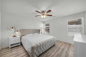 Bedroom with light wood-style flooring, a ceiling fan, and a textured ceiling