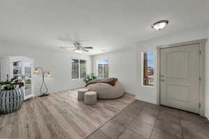 Entryway featuring a textured ceiling, light wood finished floors, and a ceiling fan