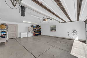 Garage featuring white refrigerator with ice dispenser and white fridge