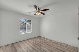 Empty room with light wood-style floors and a ceiling fan