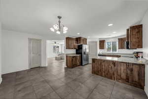 Kitchen featuring a peninsula, healthy amount of natural light, ceiling fan, and stainless steel fridge with ice dispenser