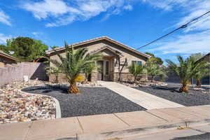 View of front facade featuring stucco siding, a tiled roof, and stone siding