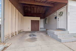 Property entrance with a patio and an attached carport
