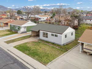 Bungalow featuring a residential view, a mountain view, a front lawn, and a shingled roof