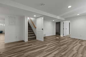 Finished basement featuring recessed lighting, dark wood finished floors, and electric panel