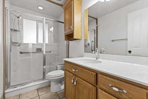 Bathroom featuring vanity, a stall shower, and light tile patterned floors
