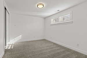 Unfurnished room with dark carpet and a textured ceiling