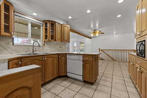 Kitchen featuring dishwasher, tasteful backsplash, glass insert cabinets, a peninsula, and recessed lighting