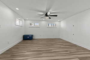 Empty room with wood finished floors, a ceiling fan, recessed lighting, and a textured ceiling