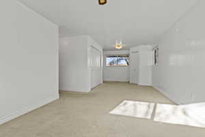 Unfurnished room with light colored carpet and baseboards