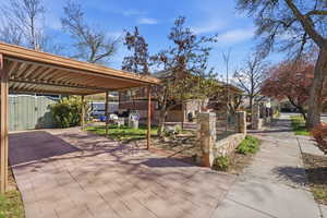 View of patio with a fenced front yard and a gate