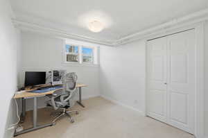 Home office featuring light carpet and baseboards