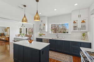 Open concept kitchen with large island, gas range, and wood floors