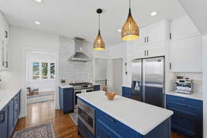 Open concept kitchen with large island, gas range, and wood floors