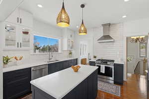 Open concept kitchen with large island, gas range, and wood floors