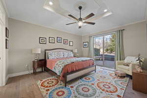 Bedroom featuring light wood-style floors, access to outside, crown molding, and a ceiling fan