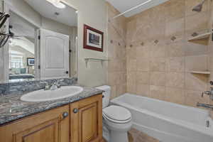 Ensuite bathroom with vanity, shower / tub combination, a ceiling fan, and light tile patterned floors