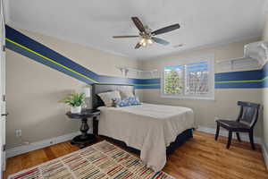 Bedroom featuring light wood-style flooring, ceiling fan, ornamental molding, and a textured ceiling