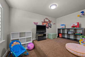Playroom featuring carpet and a textured ceiling