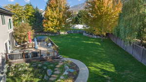 Fenced backyard featuring outdoor dining space and a deck with mountain view