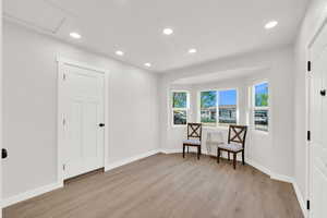 Sitting room with light wood-type flooring and recessed lighting