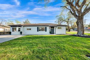 Ranch-style home featuring a front lawn, board and batten siding, and roof with shingles