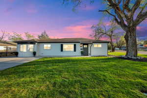 Single story home featuring a yard, board and batten siding, and a shingled roof