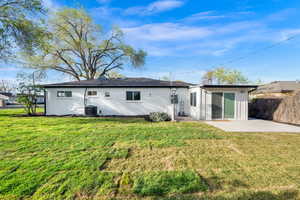 Back of house with a lawn, a patio area, and brick siding