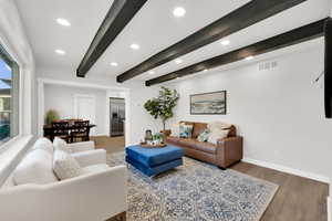 Living room featuring wood finished floors, beam ceiling, and recessed lighting