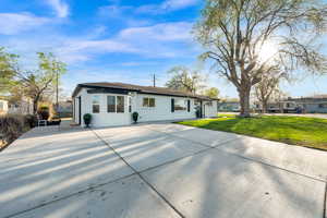 Ranch-style home featuring a front lawn and concrete driveway
