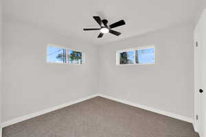 Unfurnished room with carpet floors and a ceiling fan