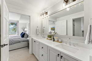 Bathroom with double vanity, ensuite bath, and light carpet