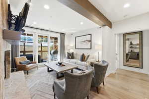 Living room featuring recessed lighting, light wood-style flooring, beam ceiling, and wine cooler