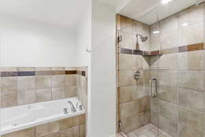 Bathroom featuring a bath and a stall shower