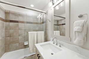Bathroom featuring vanity and enclosed tub / shower combo