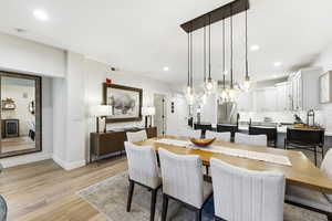 Dining area with light wood-style floors, recessed lighting, and wine cooler