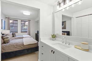 Bedroom featuring a sink and light colored carpet
