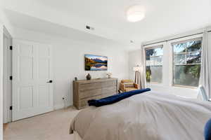 Bedroom featuring light carpet and baseboards