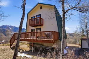 Rear view of property featuring a balcony and a deck with mountain view