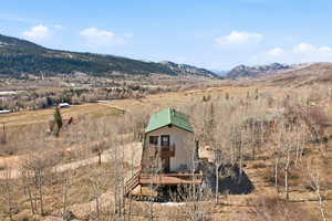 Rear view of property with a rural view, a mountain view, and a balcony