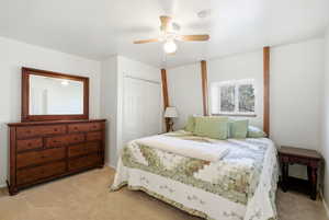 Bedroom featuring carpet, a ceiling fan, and a closet
