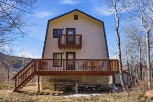 Rear view of property with a deck and a balcony