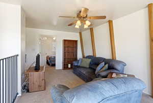 Carpeted living room with ceiling fan