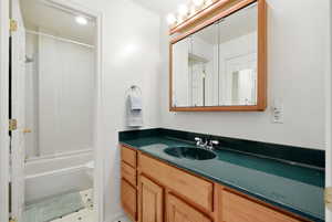 Full bathroom with vanity, shower / tub combination, and light tile patterned floors
